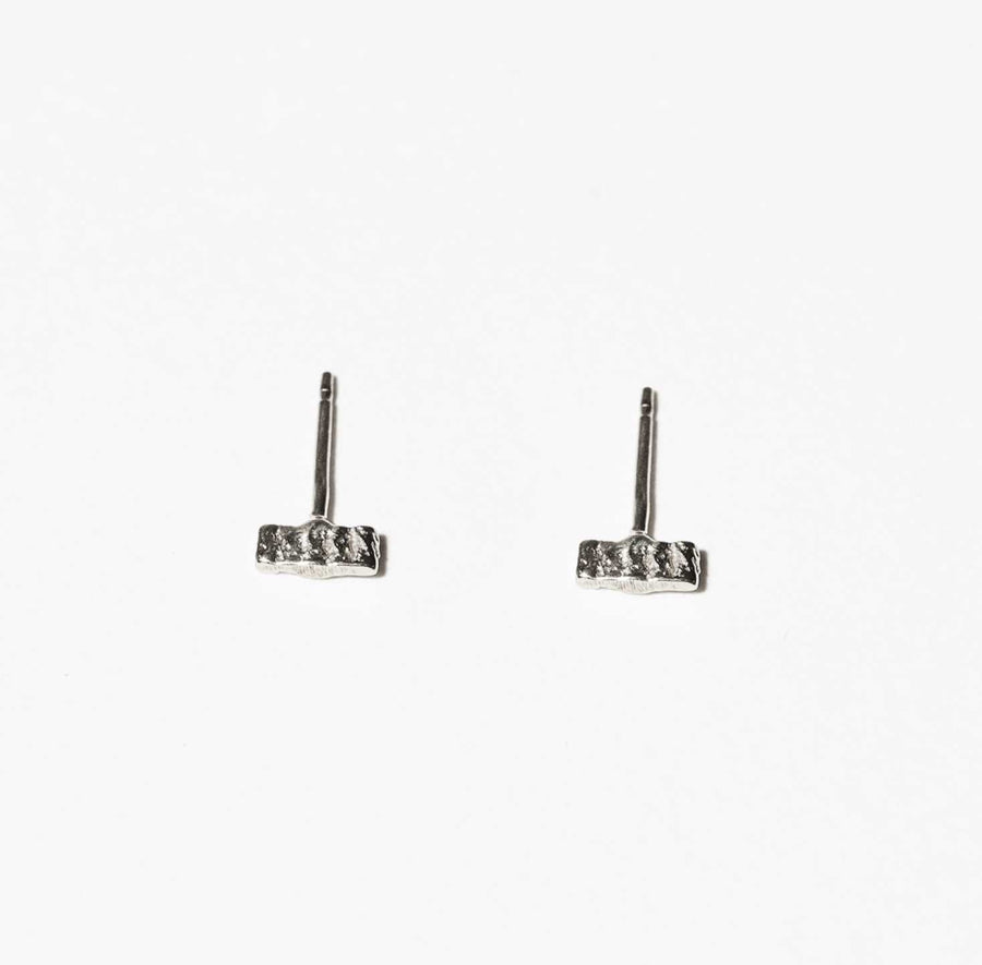 The sterling silver version of the tiny, rectangular Brick studs from COG are seen with their distinctive pattern of vertical lines.