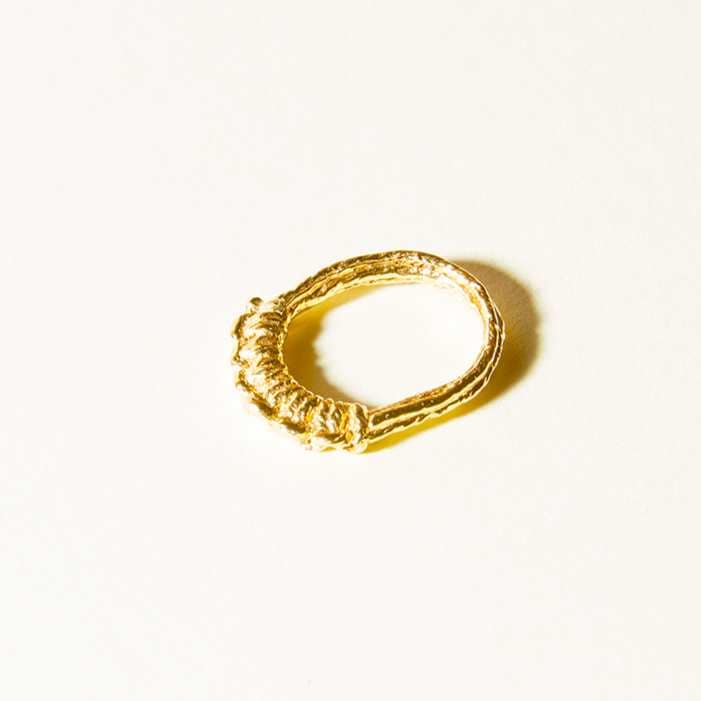 Hitch knots line the top of the ring in a raised profile. Cast from cotton threads into 14k gold plate. 