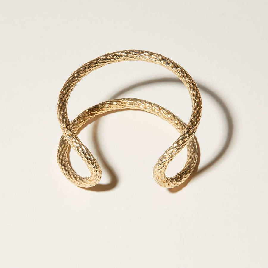 The fiber-like texture is of this cuff bracelet was created from the material it was cast from. Finished with a polished 14k gold plate.