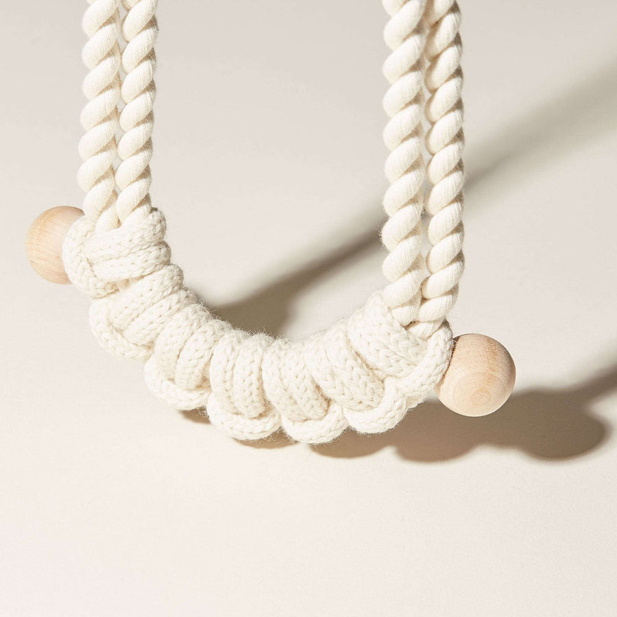 A detail of the Lines Necklace shows a row of hitch knots finished with 1 inch wood beads