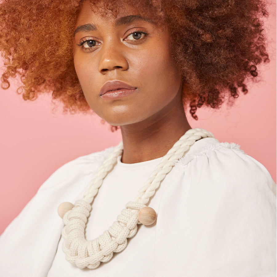 A model wears the macramé knotted necklace that includes two wood beads and a 2-ply cotton cord