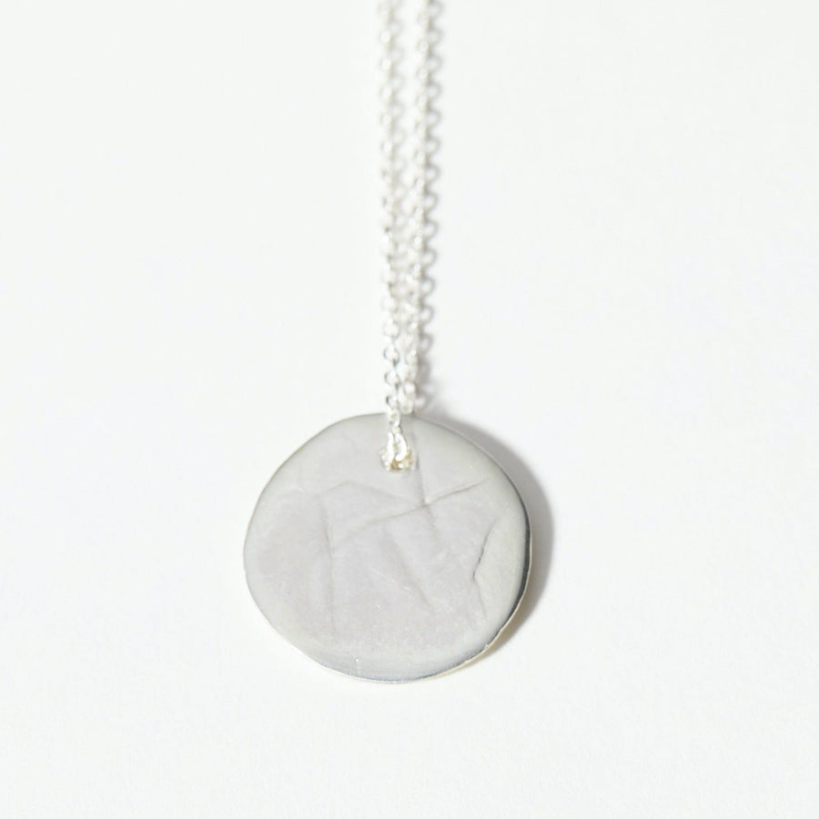The Lunar Pendant is a 1inch, round pendant molded from clay and cast in solid, sterling silver.