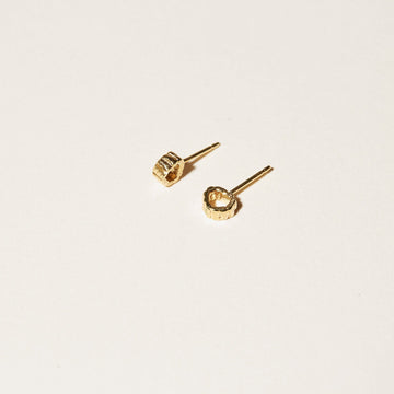 The Stern Stud earrings are round, textural and sit up in profile on your ears in 14K gold plate. 