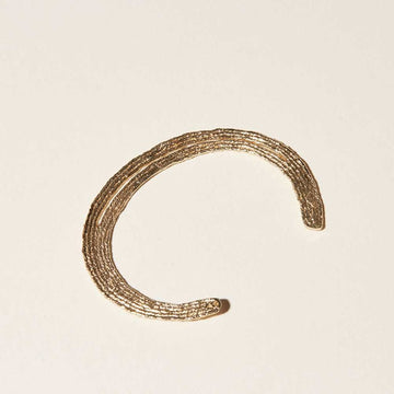 Vija Solo Cuff bracelet detail of the crescent shape, threadlike quality cast in gold plate.