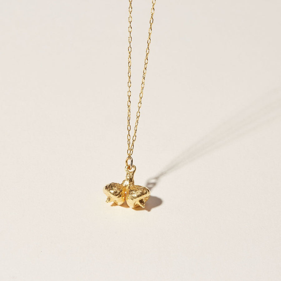 Twin acorns found on a walk in the woods have been cast into 14k gold plate and hang playfully from a delicate loop chain. An organic pendant.
