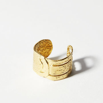 An adjustable ring that wraps a tapestry-like design around any finger. Made from carefully composed thread and cast into reclaimed brass and plated with gold.