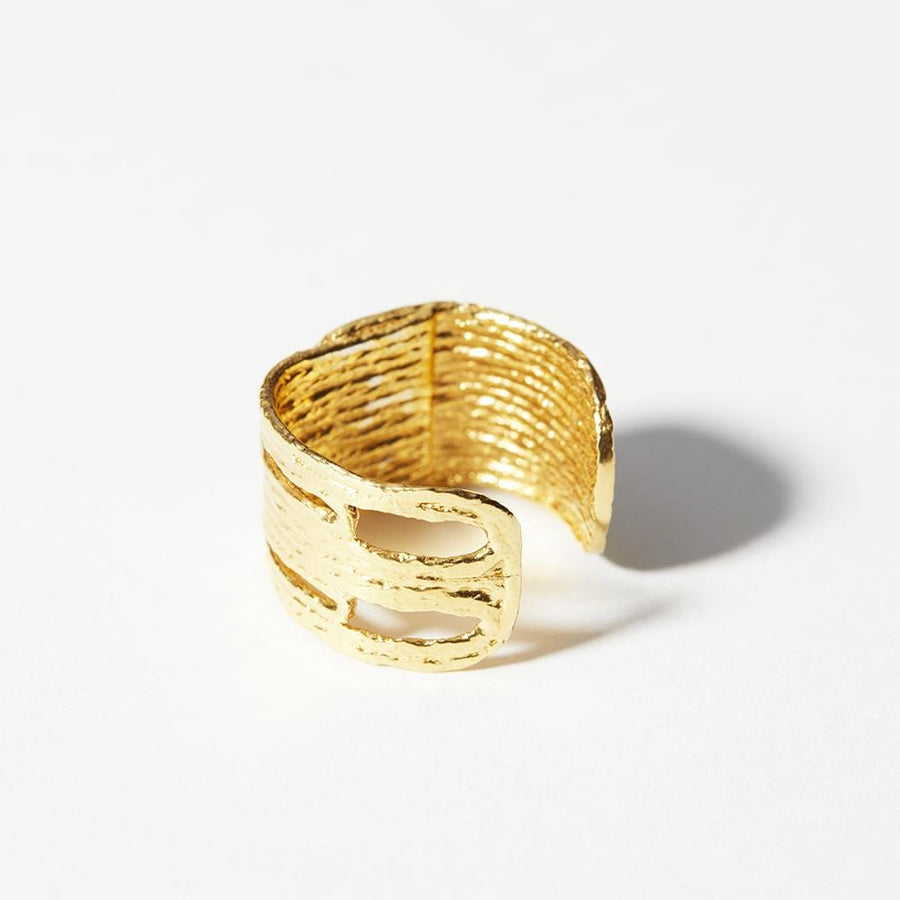 A wide band of with tapestry-like motif. This ring has a distinct pattern that resembles thread but is cast in 14k gold plated brass.